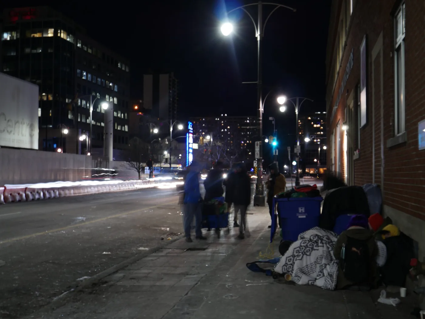 Downtown street at night with people outreaching