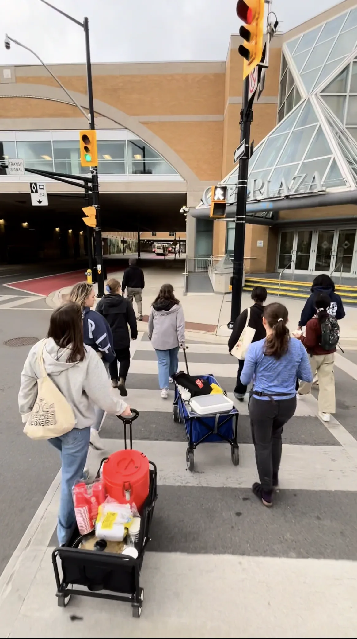 Volunteers crossing the street downtown with wagons of supplies