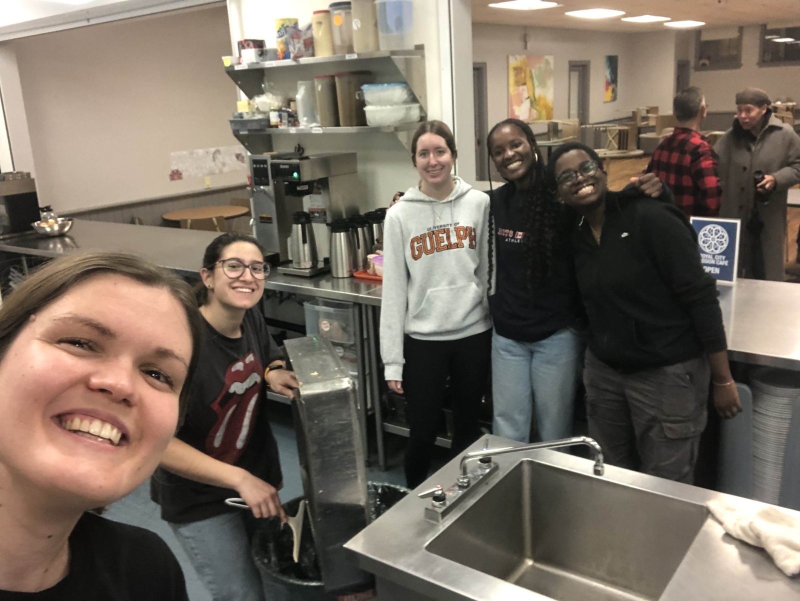 Volunteers smiling together in the Royal City Mission Cafe kitchen