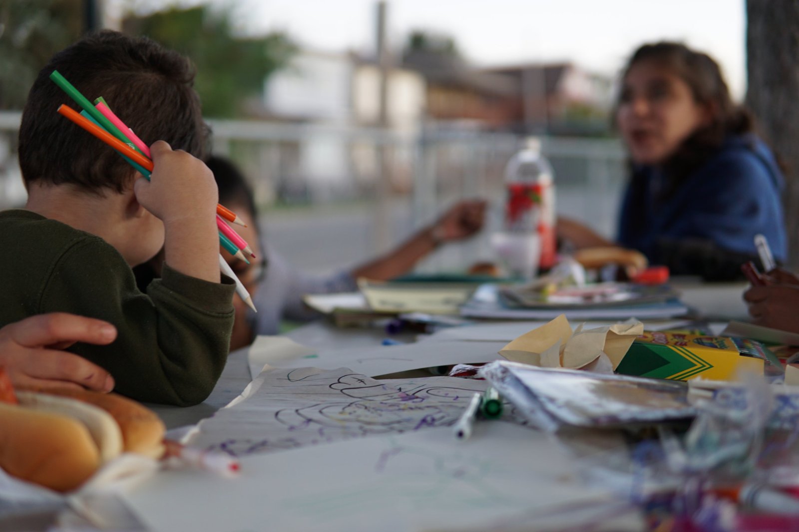 A child colouring at the community dinner